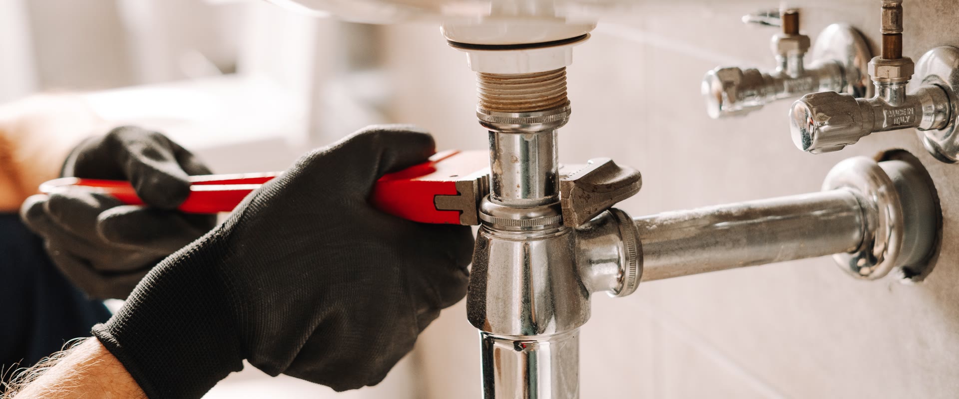 Professional plumber working on pipework